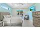 Bright main bedroom with tray ceilings, ceiling fan, TV, slider to patio and stylish light fixtures at 8084 Burwell Cir, Port Charlotte, FL 33981