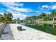 Picturesque waterfront property with a paved patio, lush palm trees, and a tranquil canal view at 8084 Burwell Cir, Port Charlotte, FL 33981