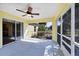 The screened in lanai has a ceiling fan and a view of the backyard at 8369 Dolomite Ave, North Port, FL 34287