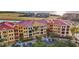 Aerial view of condos with red roofs, palm trees and parking lot at 95 Vivante Blvd # 9524, Punta Gorda, FL 33950