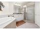 Bright bathroom with soaking tub, glass shower, granite counters, and palm accents at 95 Vivante Blvd # 9524, Punta Gorda, FL 33950