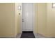 Beige apartment hallway with entrance door featuring black hardware, a door mat, and neutral tile floor at 95 Vivante Blvd # 9524, Punta Gorda, FL 33950