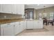 Kitchen view showcasing granite countertops, white cabinetry, dishwasher, and dining area at 95 Vivante Blvd # 204, Punta Gorda, FL 33950
