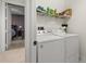 Efficient laundry room includes shelving and a washer and dryer at 95 Vivante Blvd # 9524, Punta Gorda, FL 33950
