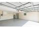 Spacious garage features an open ceiling with metal supports, painted walls, and a sealed concrete floor at 1115 Larchmont Dr, Englewood, FL 34223