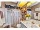 Charming bathroom with decorative vanity, a tub and shower combination, and a farmhouse-style shower curtain at 1372 Annette St, Punta Gorda, FL 33980