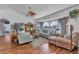 Cozy living room featuring hardwood floors, large windows, a ceiling fan, and comfortable seating at 1372 Annette St, Punta Gorda, FL 33980