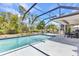 Backyard oasis featuring a screened-in pool, adjacent patio, and lush landscaping for ultimate privacy at 1372 Annette St, Punta Gorda, FL 33980