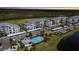 Aerial view showcasing condo buildings, pool, landscaping, and parking in a well-maintained community at 14061 Heritage Landing Blvd # 445, Punta Gorda, FL 33955