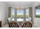 Bright dining room featuring a glass table, wicker chairs, and tropical-themed curtains at 14061 Heritage Landing Blvd # 445, Punta Gorda, FL 33955