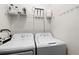 Practical laundry room with washer, dryer, storage shelf, and utility equipment for convenience at 14061 Heritage Landing Blvd # 445, Punta Gorda, FL 33955