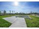 Outdoor shuffleboard court surrounded by lush greenery and palm trees on a sunny day at 14061 Heritage Landing Blvd # 445, Punta Gorda, FL 33955