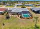Aerial view of home featuring a screened-in pool, meticulously landscaped yard and well-maintained home at 142 Rotonda Cir, Rotonda West, FL 33947