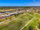 Aerial view showcasing a golf course community with a mix of residential homes and a scenic green landscape at 142 Rotonda Cir, Rotonda West, FL 33947