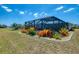 Wide shot of a backyard with vibrant landscaping, a screened enclosure and well-maintained lawn at 142 Rotonda Cir, Rotonda West, FL 33947