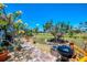 Landscaped backyard with a brick walkway, barbecue grill, mature trees, and view of the golf course at 142 Rotonda Cir, Rotonda West, FL 33947