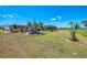 Expansive backyard with manicured lawn, mature trees, and a screened-in pool enclosure at 142 Rotonda Cir, Rotonda West, FL 33947