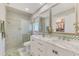 Bright bathroom featuring a double sink vanity with marble countertop, tiled shower, and walk-in closet at 142 Rotonda Cir, Rotonda West, FL 33947