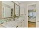 Bright bathroom showcasing a vanity with double sinks and marble countertop, and an entrance to the main bedroom at 142 Rotonda Cir, Rotonda West, FL 33947