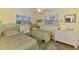Charming bedroom with two twin beds, bright yellow walls, and windows offering natural light at 142 Rotonda Cir, Rotonda West, FL 33947