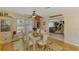 Light-filled dining room with ceiling fan, seating for six, and view into the living room at 142 Rotonda Cir, Rotonda West, FL 33947