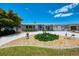 Charming single-story home featuring a well-manicured front yard with mature tree, decorative statues, and a private driveway at 142 Rotonda Cir, Rotonda West, FL 33947