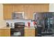 Charming kitchen features wooden cabinets, stone backsplash, and modern, black appliances at 142 Rotonda Cir, Rotonda West, FL 33947