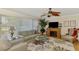 Bright and airy living room with a fireplace, ceiling fan, and large windows for ample natural light at 142 Rotonda Cir, Rotonda West, FL 33947