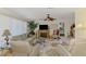 Cozy living room with a decorative fireplace, ceiling fan, and comfortable seating, perfect for relaxation at 142 Rotonda Cir, Rotonda West, FL 33947