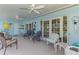 Covered patio featuring blue walls, ceiling fans, tiled flooring, and comfortable seating at 142 Rotonda Cir, Rotonda West, FL 33947