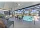 Screened-in pool area with ceiling fans, wicker furniture, and a clear view of the golf course at 142 Rotonda Cir, Rotonda West, FL 33947