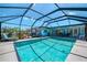 A sparkling blue pool with a screened enclosure and an adjacent covered patio area at 142 Rotonda Cir, Rotonda West, FL 33947
