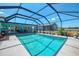 Screened-in pool area with clear blue water, offering a relaxing outdoor space with views of the backyard at 142 Rotonda Cir, Rotonda West, FL 33947