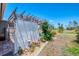 Grassy yard with a wooden pergola, lattice fence, and various potted plants and shrubbery at 142 Rotonda Cir, Rotonda West, FL 33947