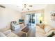 Bright living room featuring neutral tones, ceiling fan, and a sliding glass door to the patio at 1515 Forrest Nelson Blvd # N101, Port Charlotte, FL 33952