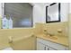 Retro yellow-tiled bathroom features a built-in sink with storage and a large window at 159 Godfrey Ne Ave, Port Charlotte, FL 33952