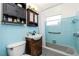 Bathroom with blue tile has a sink, toilet, shower-tub combo, storage and overhead lighting at 159 Godfrey Ne Ave, Port Charlotte, FL 33952