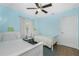 Bright bedroom with light blue walls, two twin beds, and a ceiling fan at 159 Godfrey Ne Ave, Port Charlotte, FL 33952