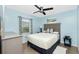 This light blue bedroom has a full bed, dark gray furniture, and views of the fenced yard at 159 Godfrey Ne Ave, Port Charlotte, FL 33952
