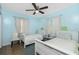 Charming bedroom featuring two twin beds, soft blue walls, and a ceiling fan at 159 Godfrey Ne Ave, Port Charlotte, FL 33952