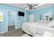 Light blue bedroom features a queen bed, TV, ceiling fan, and doorway to a walk-in closet at 159 Godfrey Ne Ave, Port Charlotte, FL 33952