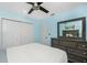 Light blue bedroom with large dresser, closet and a full bed features an overhead ceiling fan at 159 Godfrey Ne Ave, Port Charlotte, FL 33952
