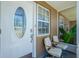 Inviting front porch with seating and decorative glass door, enhancing curb appeal at 159 Godfrey Ne Ave, Port Charlotte, FL 33952