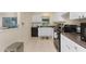 Bright kitchen with white cabinets, black appliances, and a view to the outside at 159 Godfrey Ne Ave, Port Charlotte, FL 33952