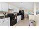 Functional kitchen with black appliances, white cabinetry, and access to the dining area at 159 Godfrey Ne Ave, Port Charlotte, FL 33952