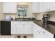 Bright kitchen area with white cabinets, dark countertops, and stainless steel sink at 159 Godfrey Ne Ave, Port Charlotte, FL 33952