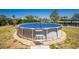 A backyard featuring an above-ground pool, surrounded by gravel and greenery, offering an outdoor retreat at 159 Godfrey Ne Ave, Port Charlotte, FL 33952