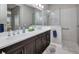 Spacious bathroom with double sinks, dark wood cabinetry, and a luxurious glass walk-in shower at 1678 Royal Ct, Punta Gorda, FL 33980