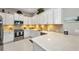 Open-concept kitchen with stainless steel appliances, bright white cabinetry, and modern countertops and fixtures at 1678 Royal Ct, Punta Gorda, FL 33980
