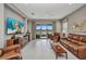 Comfortable living room featuring tile floors, modern furniture, and a large sliding glass door leading to a lanai at 1678 Royal Ct, Punta Gorda, FL 33980